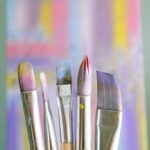 Art brushes with abstract painted canvas in vibrant colors.